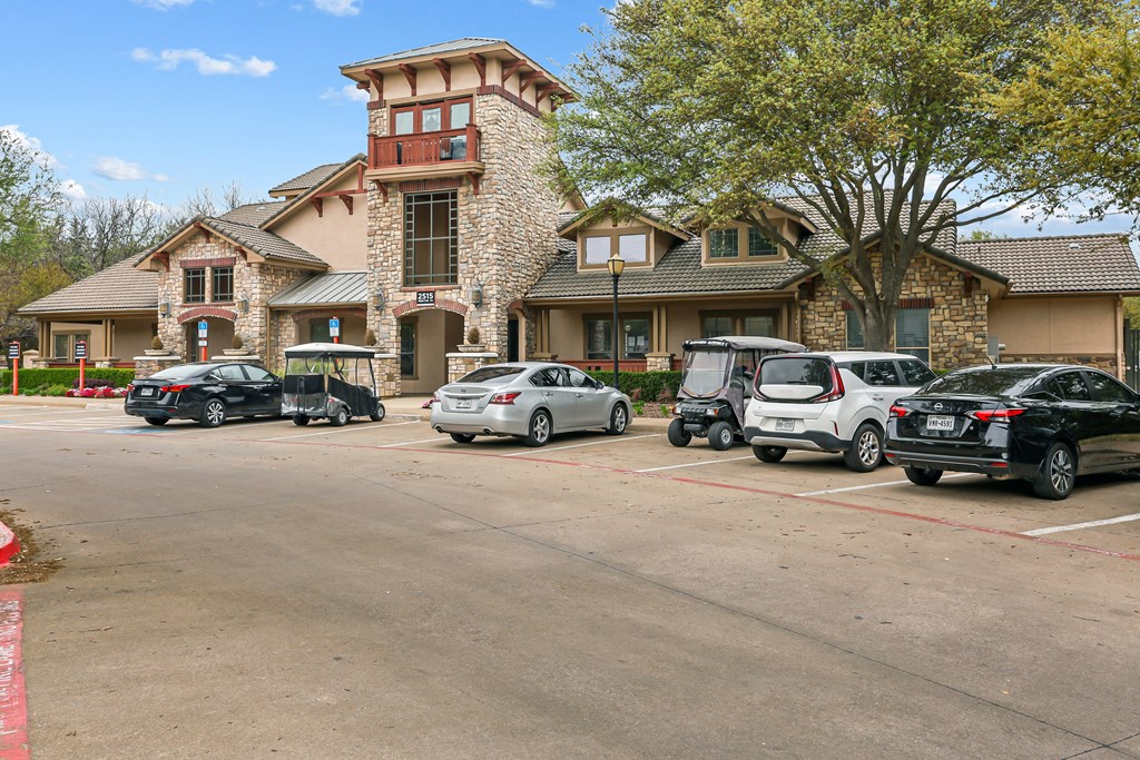 A parking lot with cars and a building in the background.