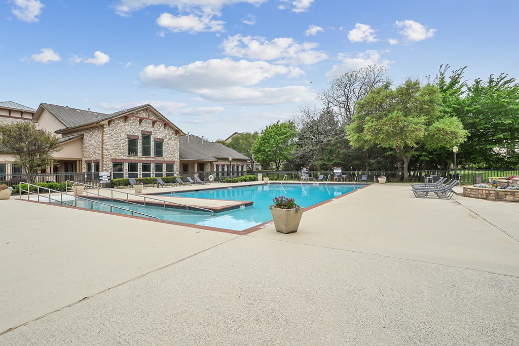 A large outdoor swimming pool with a building in the background.