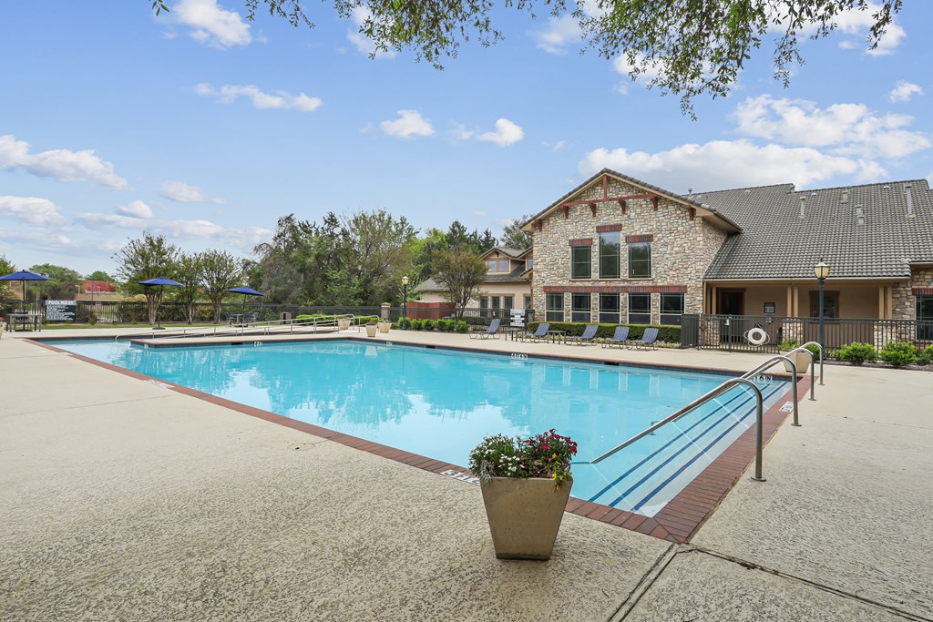 A pool with a building behind it.