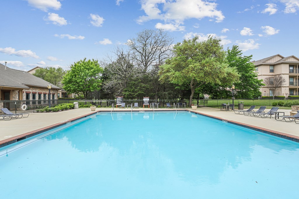 A large swimming pool in a sunny outdoor setting.