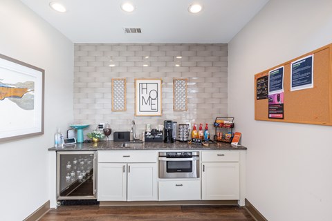 A kitchen with white cabinets and a black countertop.