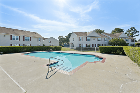 A swimming pool in a residential area with houses in the background.