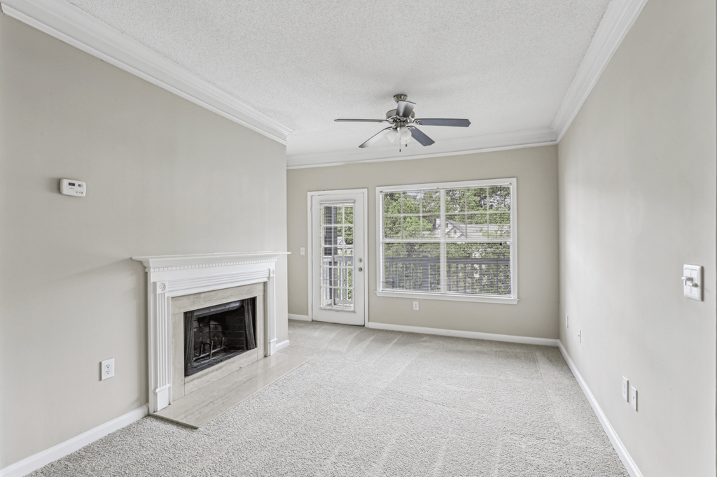 living room with carpeted flooring, ceiling fan, and fireplace