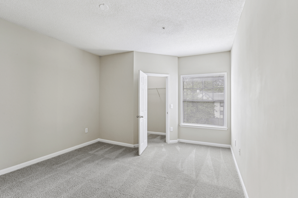bedroom with carpeted flooring and walk-in closet