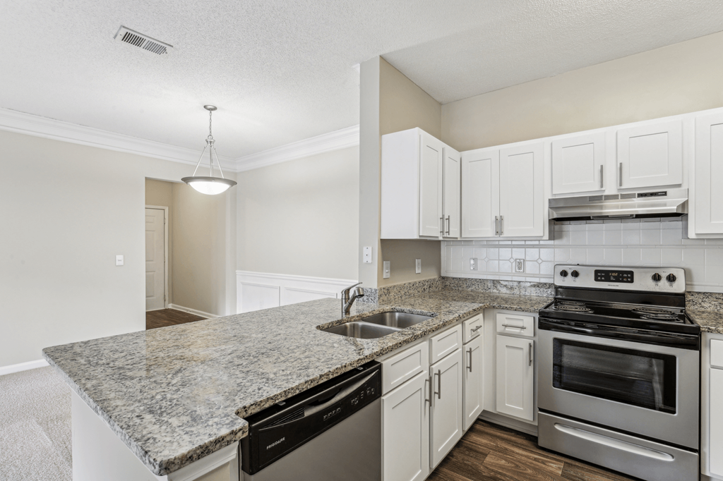 kitchen with white cabinetry, stainless steel appliances, and granite-style countertops