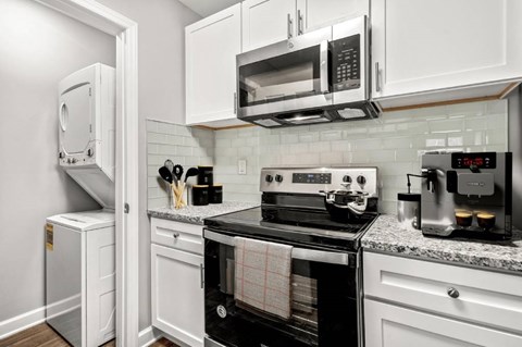 a kitchen with white cabinetry and black appliances