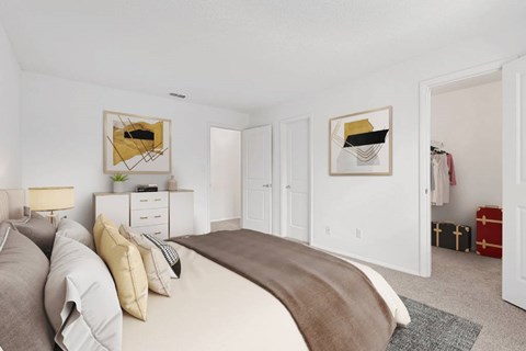 a bedroom with white walls and a large bed with a brown blanket