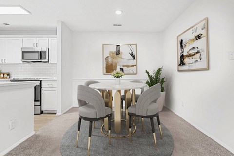 a dining area with a round table and four chairs