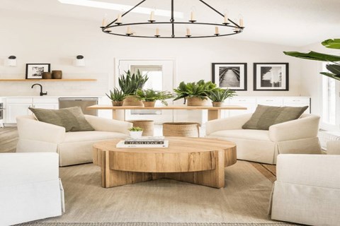 a living room with white furniture and a large circular chandelier