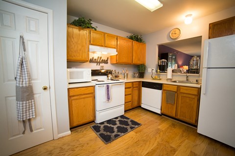 A kitchen with wooden cabinets and white appliances.