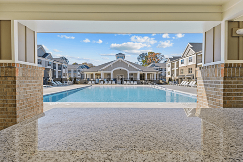 Swimming pool area facing the resident clubhouse with natural landscaping