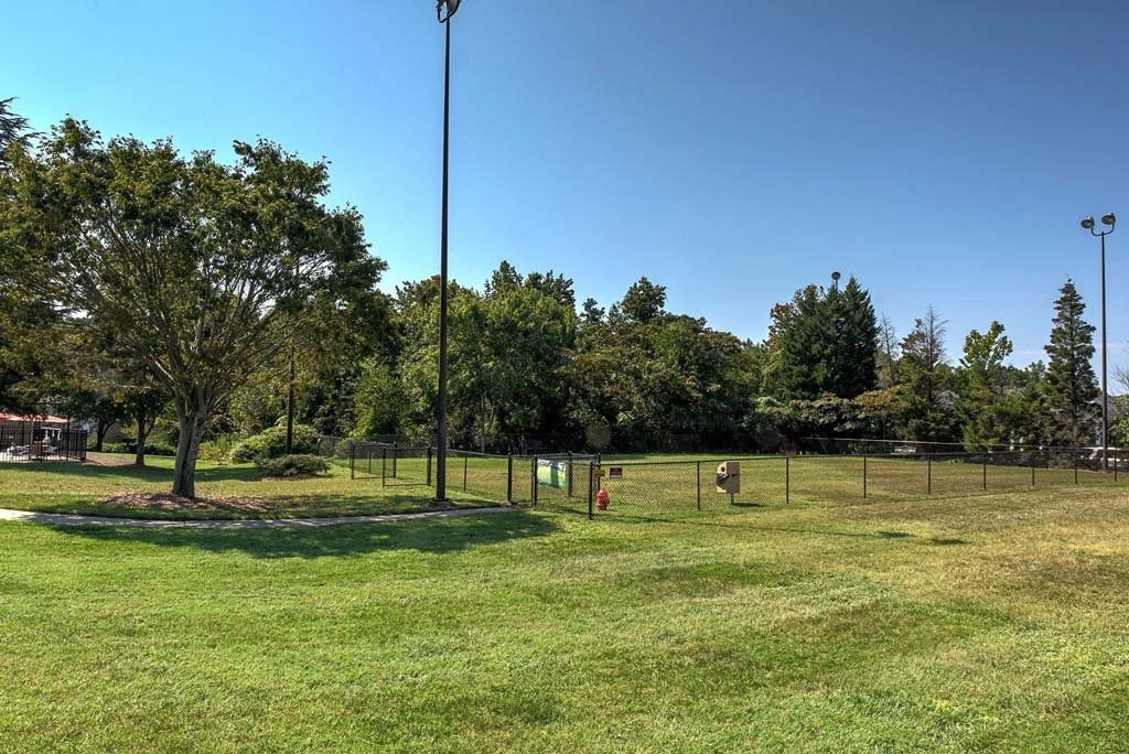 A park with a green grass field and trees at Fox Hollow Apartment Homes, High Point, NC