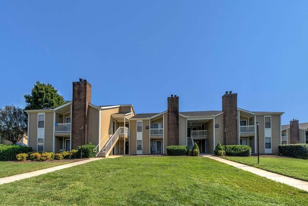 A row of apartment buildings with a clear blue sky above at Fox Hollow Apartment Homes, High Point, North Carolina