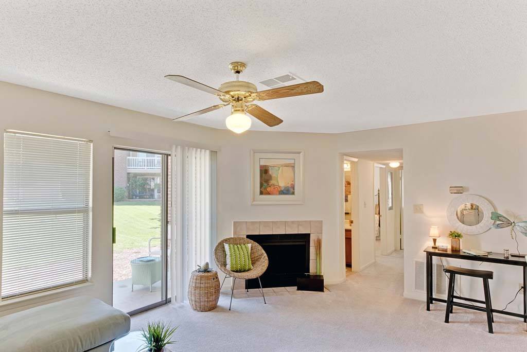 A living room with a fireplace, a chair, and a painting on the wall.