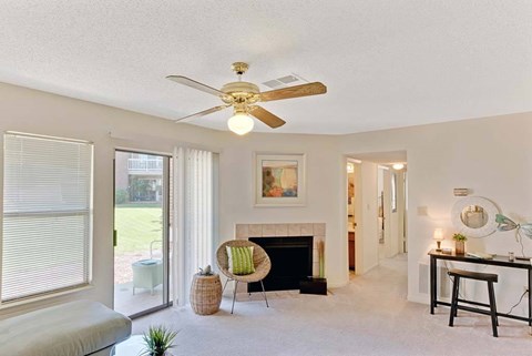 A living room with a fireplace, a chair, and a painting on the wall at Fox Hollow Apartment Homes, High Point, NC