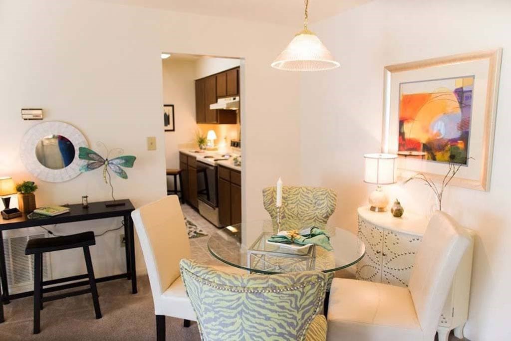 A modern dining room with a glass table and chairs at Fox Hollow Apartment Homes, High Point, 27265