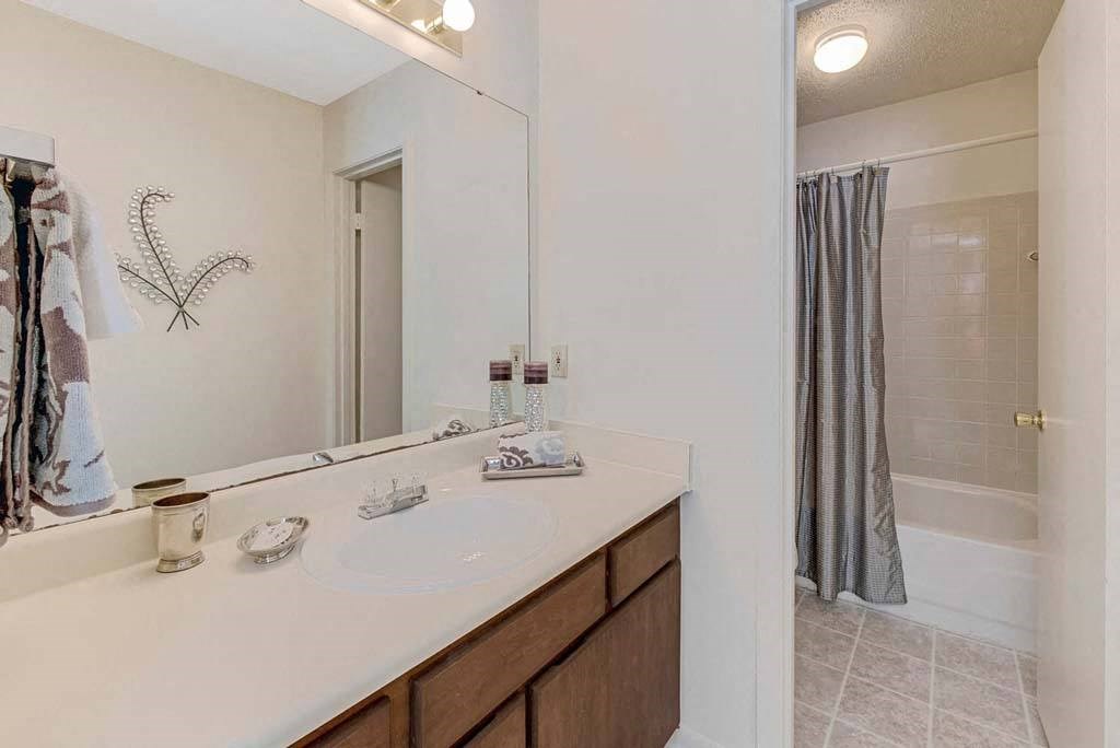 A bathroom with a white countertop and a mirror above it at Fox Hollow Apartment Homes, High Point, NC, 27265