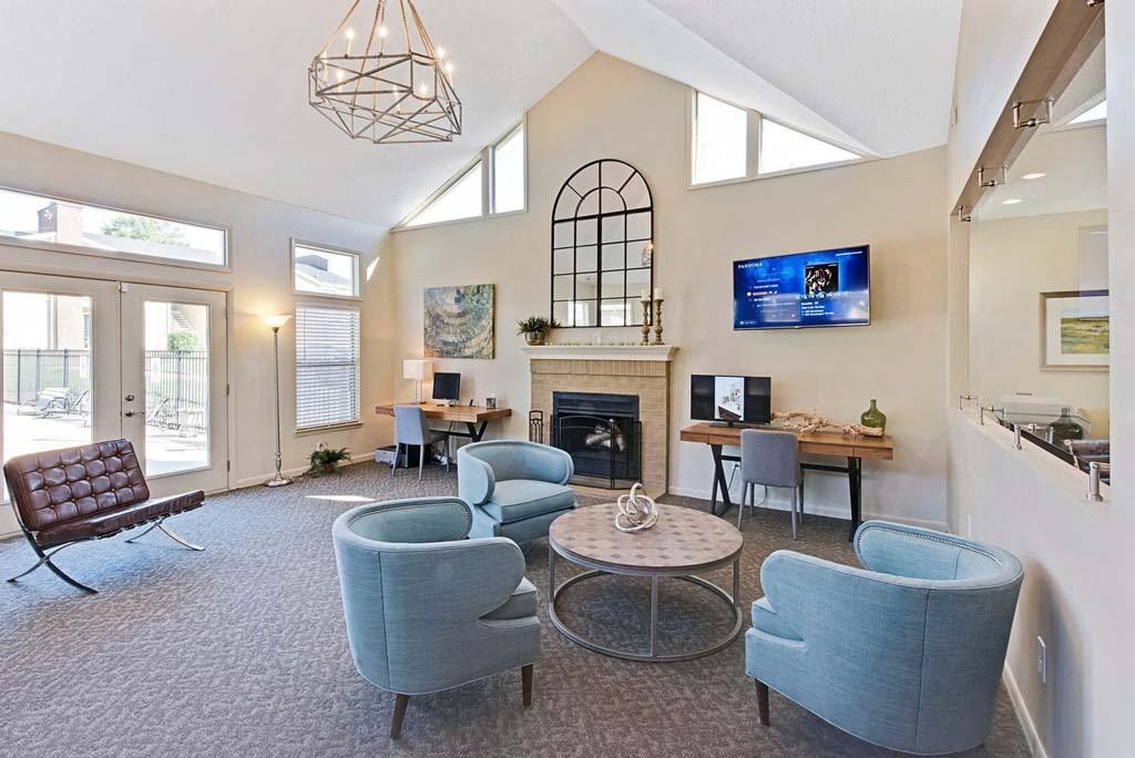 A living room with a fireplace and a TV mounted on the wall at Fox Hollow Apartment Homes, High Point