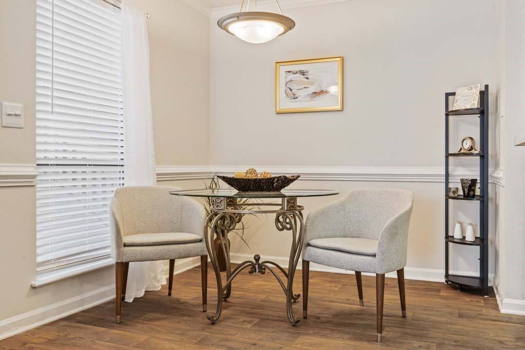 A dining room with a table and two chairs.