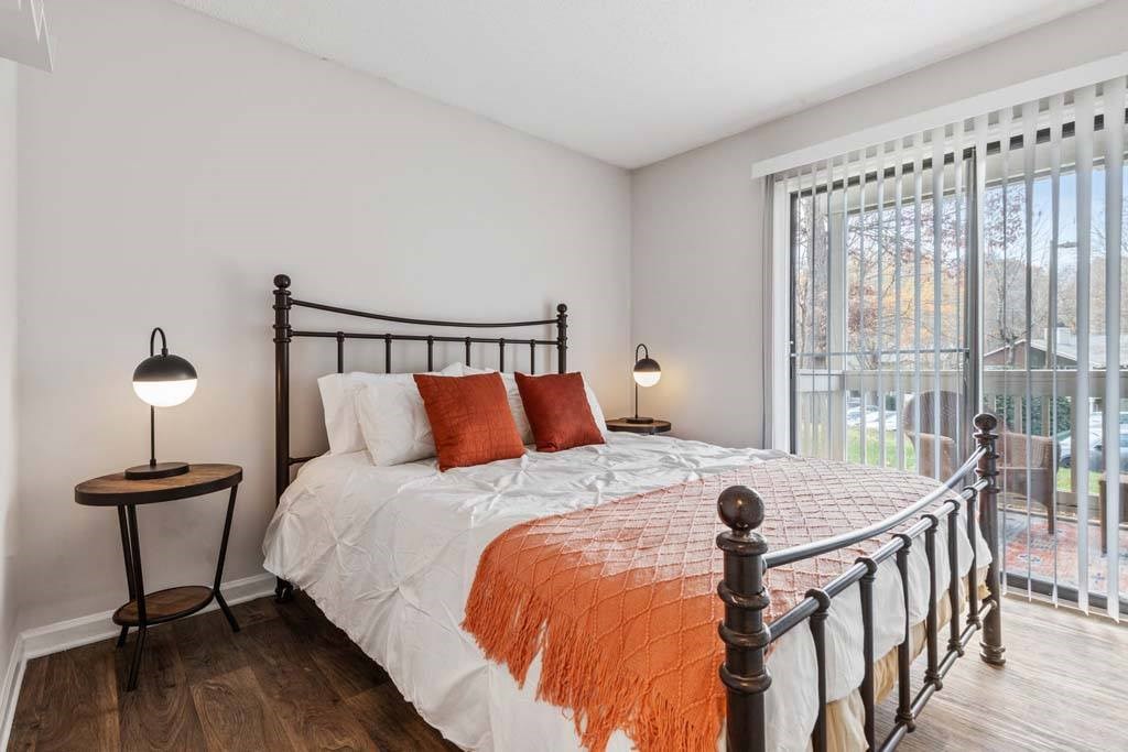 A bedroom with a large bed and a balcony.