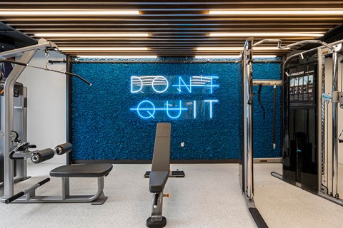 a gym with a blue neon sign on the wall and a gym chair