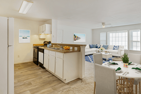 A kitchen with white cabinets and a dining table set for two.