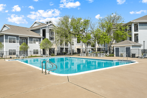 A swimming pool in front of apartment buildings.