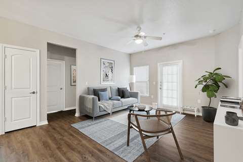 A living room with a grey couch and a wooden chair.