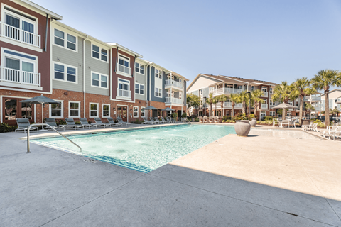 A swimming pool in front of apartment buildings.