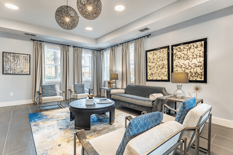 A living room with a black coffee table and a blue rug.
