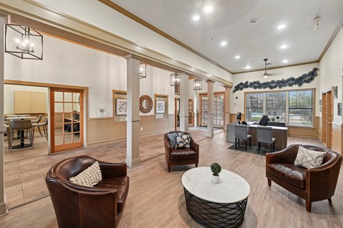 A living room with brown leather chairs and a white coffee table.