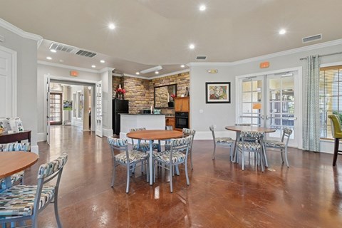 A dining room with a wooden table surrounded by chairs.