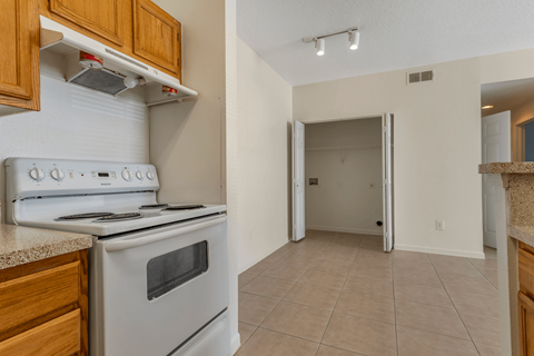 A white stove and oven in a kitchen with wooden cabinets.