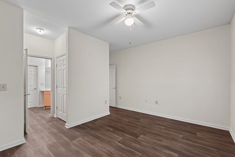 A room with a ceiling fan and wooden flooring.