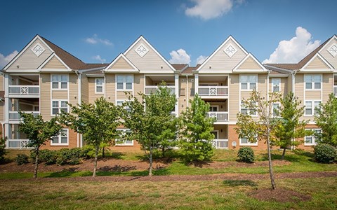 Apartment complex with trees in front of it.