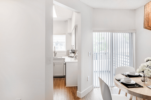 A white kitchen with a dining table and chairs.