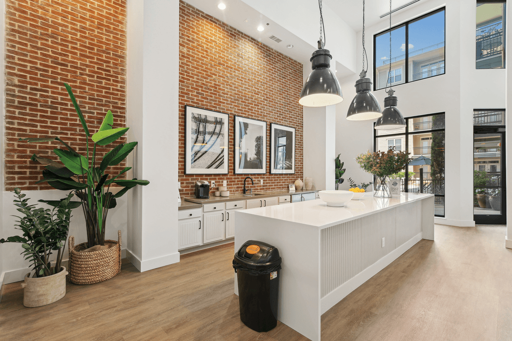 a kitchen with a large white island and a brick wall