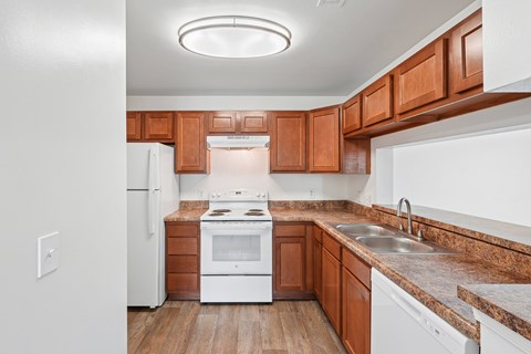 A kitchen with wooden cabinets and a white refrigerator.