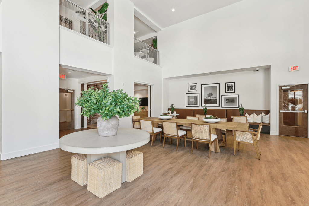 a dining room with a table and chairs and a vase of flowers