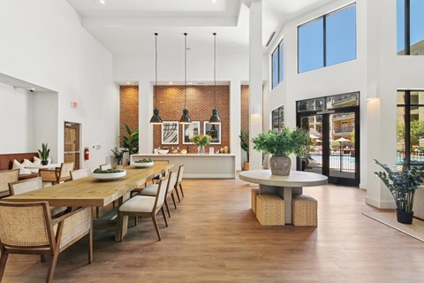 A modern dining room with a long wooden table and chairs.