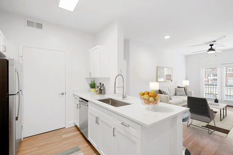 A modern kitchen with white cabinets and a black refrigerator.