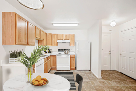 A kitchen with wooden cabinets and a white refrigerator.