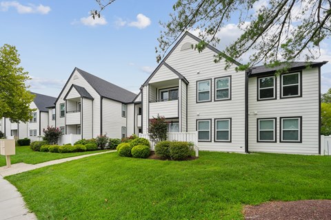 A row of houses with green lawns in front.