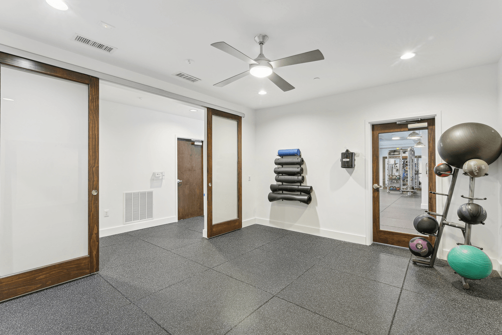 a workout room with a ceiling fan and exercise equipment