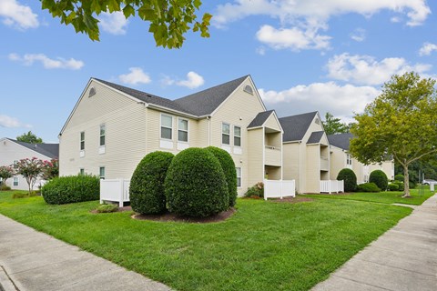 A residential building with a green lawn in front.