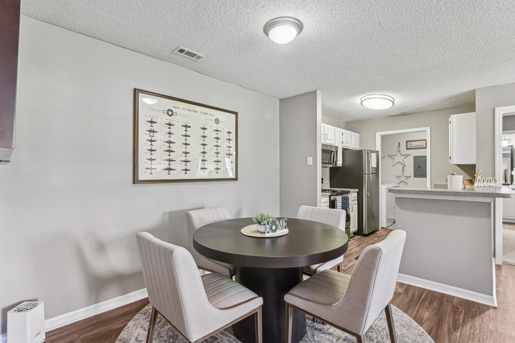 a dining room with a table and chairs and a kitchen