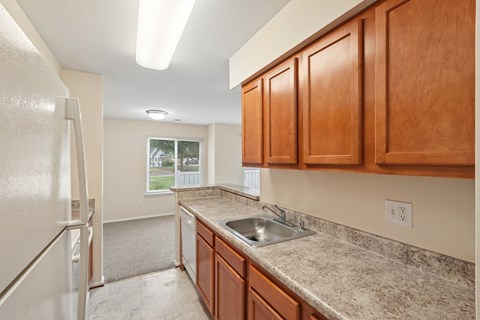 A kitchen with wooden cabinets and a granite countertop.