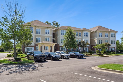 A row of cars are parked in front of a building.