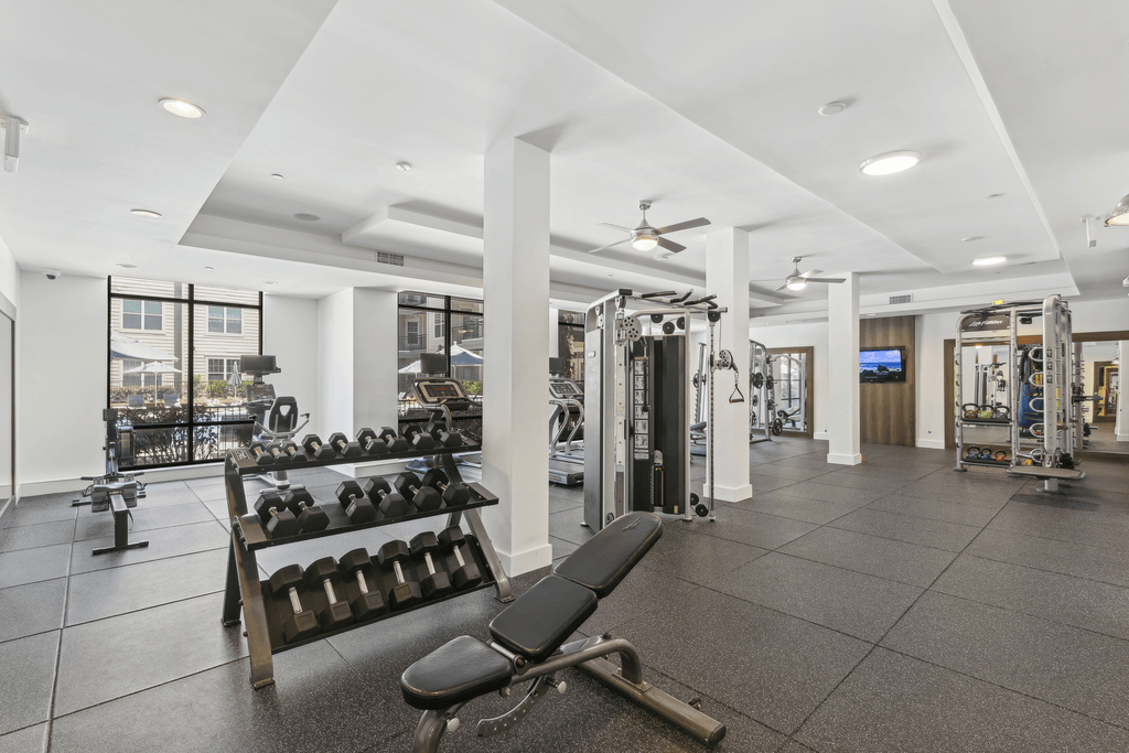 a gym with weights and other equipment in a building with windows