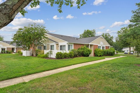 A house with a white fence and a green lawn.